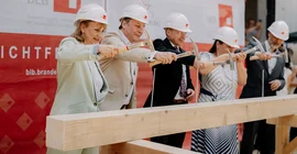 Die Technische Geschäftsführerin des Brandenburgischen Landesbetriebes für Liegenschaften und Bauen (BLB) Gerit Fischer, Universitätspräsident Prof. Oliver Günther, Ph. D., der für den Landesbau zuständige Finanzstaatssekretär Frank Stolper, Wissenschaftsministerin Dr. Manja Schüle sowie der Architekt Prof. José Gutierrez Marquez (v.l.n.r.) schlugen symbolisch die letzten Nägel ein.