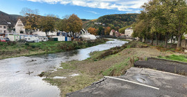 Blick über einen Fluss, der eine Überquerung weggerissen hat.