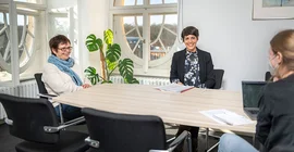 Prof. Dr. Barbara Höhle (links) und Dr. Nina Khan (rechts) am Tisch mit Interviewpartnerin Dr. Jana Scholz. Das Foto ist von Thomas Roese