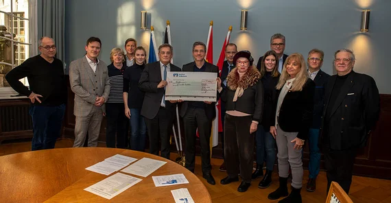 Potsdams Oberbürgermeister Mike Schubert und der Vizepräsident für Internationales und Fundraising der Universität Potsdam Prof. Dr. Florian Schweigert mit Vertreterinnen und Vertretern der Potsdamer Serviceclubs bei der Scheckübergabe am 12. Dezember im Stadthaus.