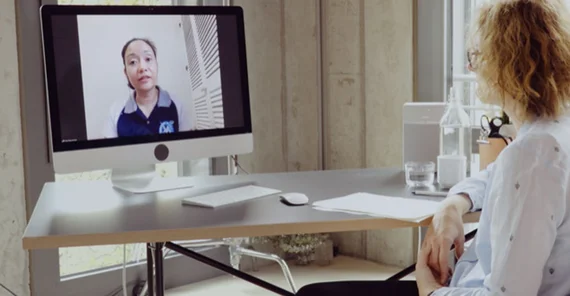 Person sitzt vor einem PC und nimmt an einer Videokonferenz teil. Das Foto ist von Nina Keinrath.