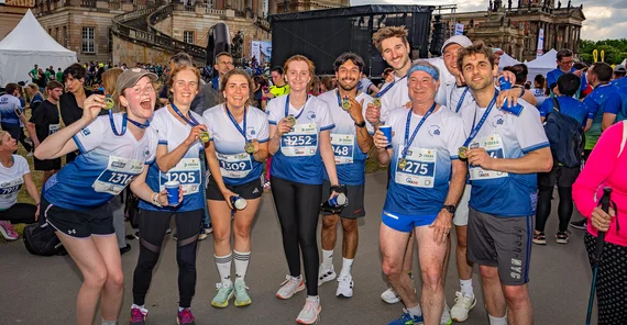 Gruppe von Menschen in Sportkleidung glücklich im Ziel.