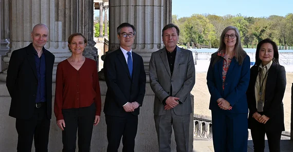 Sechs Personen posieren für ein Foto am Haus 9 am Campus Am Neuen Palais.