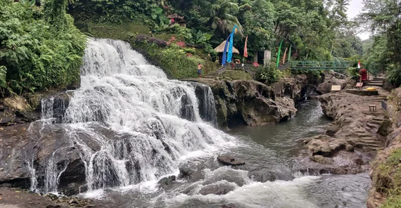 Wasserfall bei Ubud. Der sichtbare Ausschnitt stürzt aus fast 10m Höhe über Felstreppen in ein Flussbett.