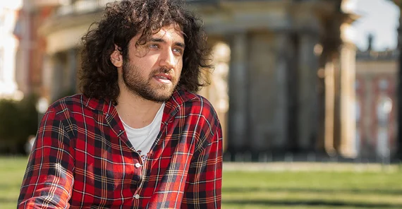 Student Hikmet Güler sitzt am Campus Neues Palais