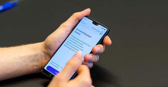 Jemand hält ein Smartphone in den Händen und hat die App von memodio geöffnet.