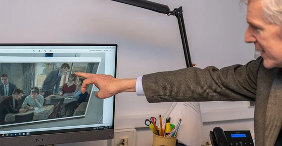 Ralf Müller zeigt auf einen PC-Monitor, das ein Bild von Studierenden beim „Selbstlernen“ zeigt.