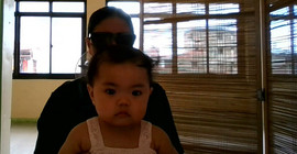 Baby sitzt auf dem Schoß seiner Mutter