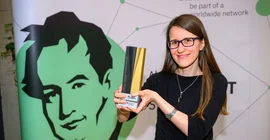 Porträt einer Frau, die einen Preis in die Höhe hält