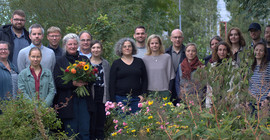 Fast 20 Vertretende verschiedener Einrichtungen Brandenburgs posieren für ein Gruppenbild im Campusgarten der FH Potsdam.