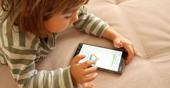 Kleinkind spielt mit Smartphone.