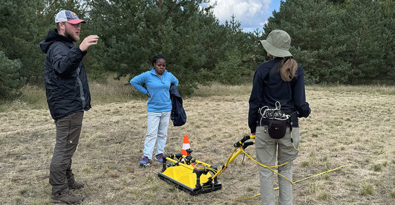 Philipp Koyan (left) discusses the procedure for georadar measurements with Mercy Ekua Grimmon-Thompson (center) and Paulina Nitschke (right).