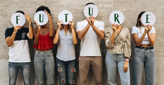 Gruppe von sechs jungen Menschen steht in einer Reihe und hält die Buchstaben des Wortes "Future" vor die Gesichter