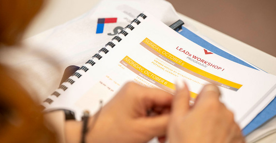 Close-Up auf Unterlagen und Hände einer teilnehmenden Person.