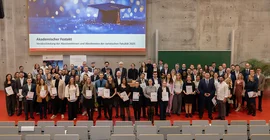 Gruppe von Menschen, die in einem Hörsaal fürs Foto zusammensteht