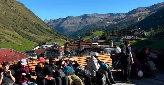 A group of people in alpine region having a break. They seem to be exhausted but happy.