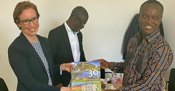 Eine Frau übergibt einem Mann ein Buch als Geschenk.