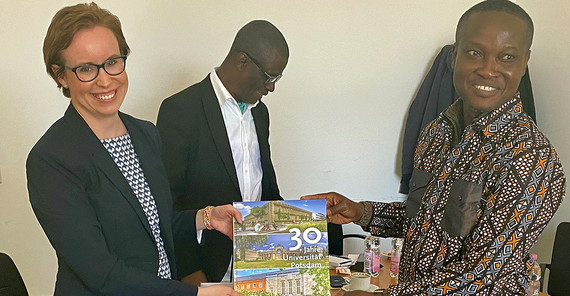 Eine Frau übergibt einem Mann ein Buch als Geschenk.