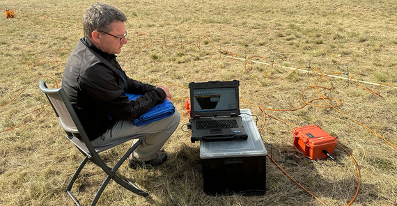 Jens Tronicke follows the progress of geoelectrical measurement on a field laptop.