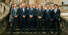 Gruppe von Menschen haben sich auf einer Treppe für ein Gruppenfoto aufgestellt