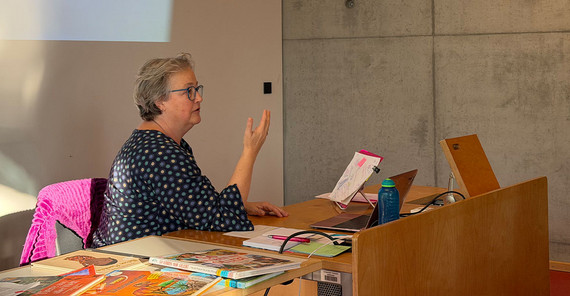 Person hält sitzend einen Vortrag.