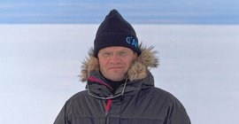 Prof. Dr. Markus Rex im Porträt vor eisigem Horizont auf Expedition in der Antarktis.