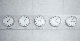 Das Bild zeigt fünf Wanduhren mit unterschiedlichen Uhrzeiten.